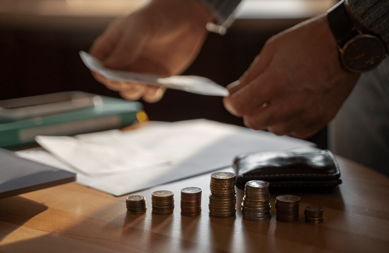 a stack of coins and a hand holding a paper